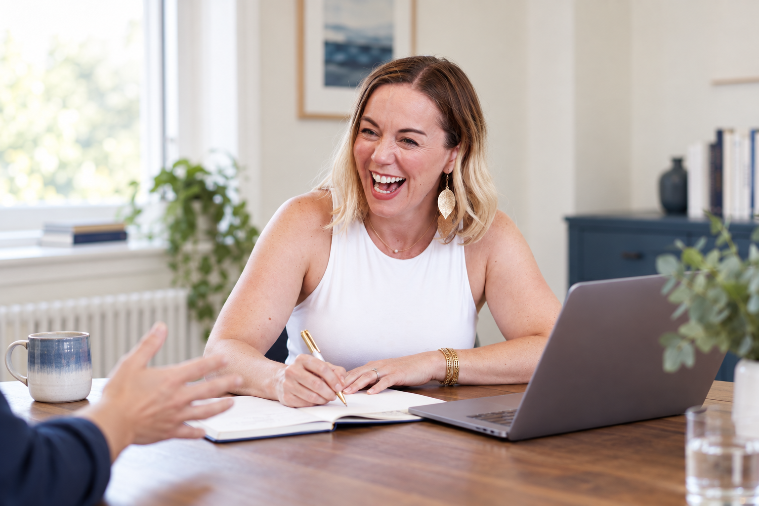 Illustrative consultation scene with Sarah and a client’s hand visible