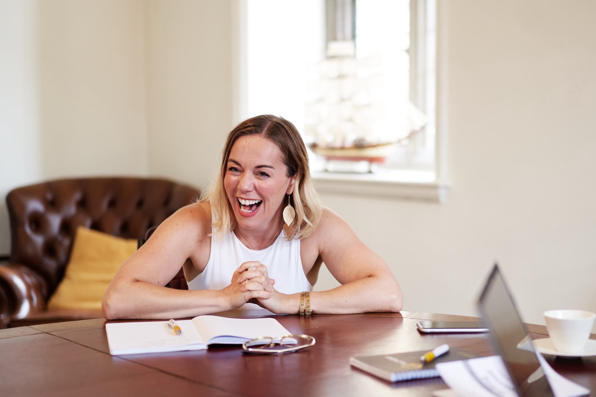 Sarah laughing during a conversation at a table